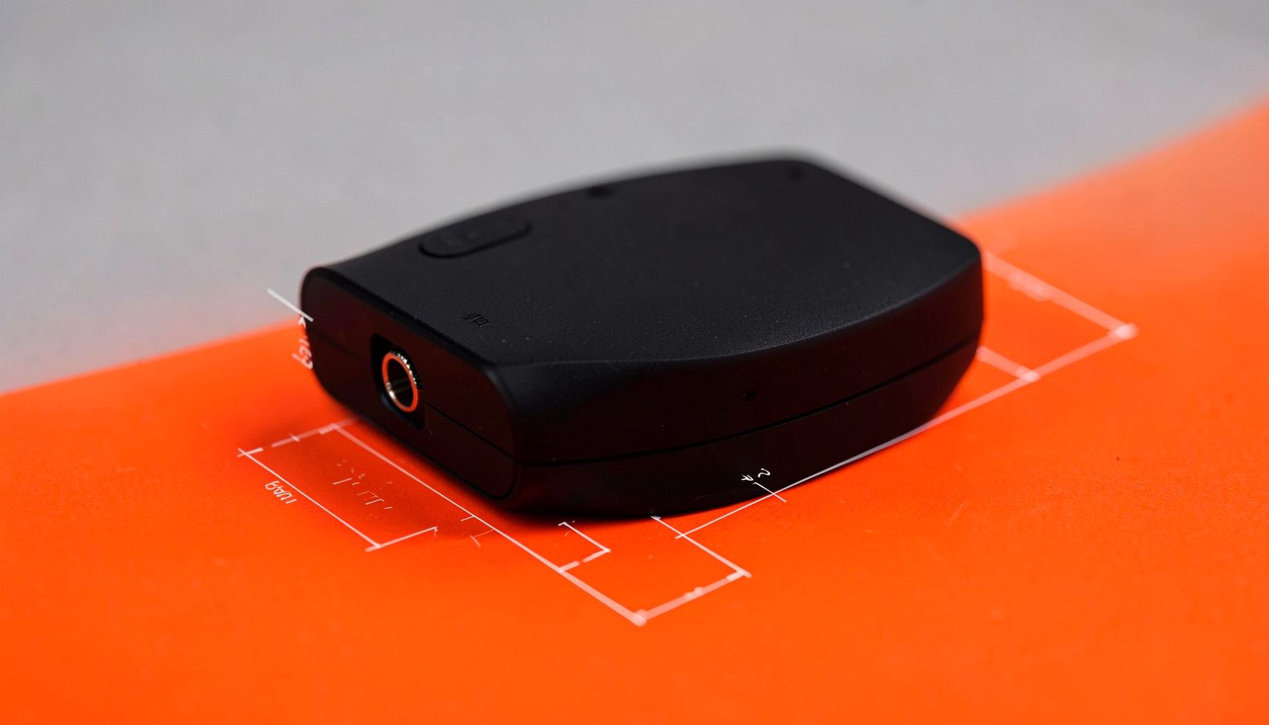 A second Bluetooth transmitter model in matte black with a 3.5mm jack, photographed on a soft gray surface